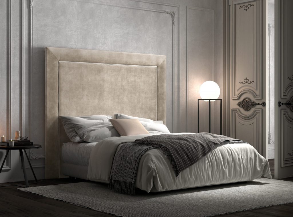 Polstermöbel Bettkopfteil Renia aus der DMG Kollektion in schlichtem, geradlinigem Design. Kombiniert mit einem Bett in opulent-romantischem Ambiente: Stuckkasetten an Wänden und Decke, moderne Lampe mit kugelförmigem Leuchtkörper, kleiner Beistelltisch als Nachtkästchen sowie leger arrangiertes Bettzeug mit Plaid