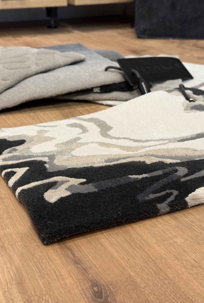 Getuftete Teppichmuster in unterschiedlichen Materialien, Florhöhen und Farbnuancen, ausgelegt zum Vergleich von Struktur und Wirkung im Raum