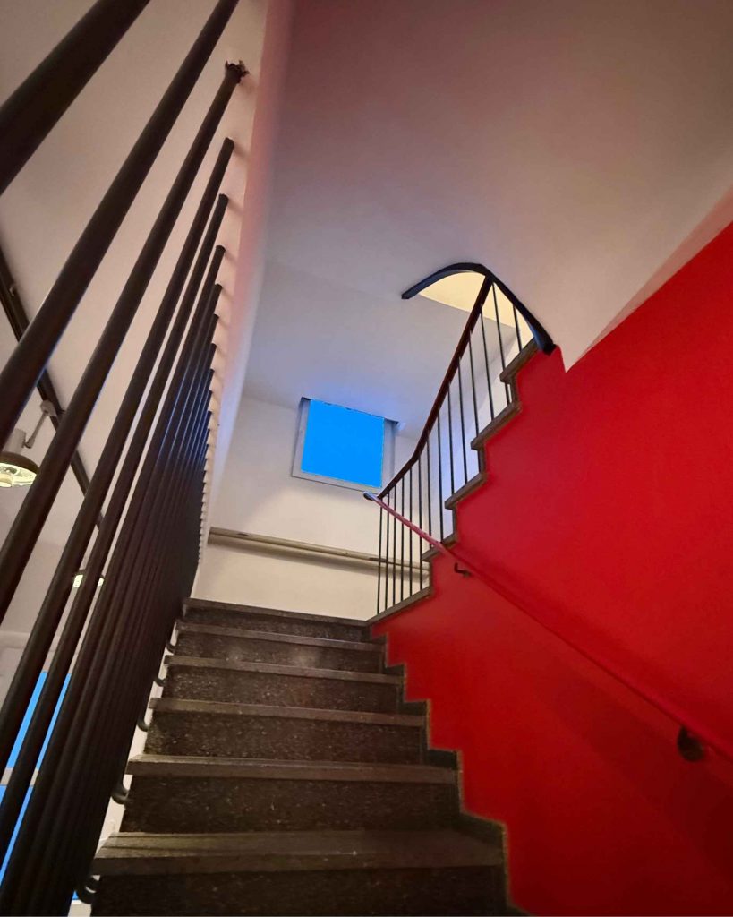 Blick durch das Treppenhaus nach oben mit installierten Deckenpaneelen zur Verbesserung der Raumakustik