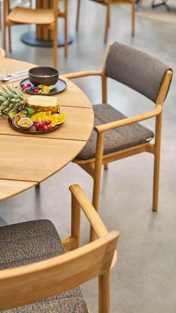 Weishäupl Teva Armlehnstühle aus Teakholz an rundem Tisch mit Früchteplatte, Detailansicht