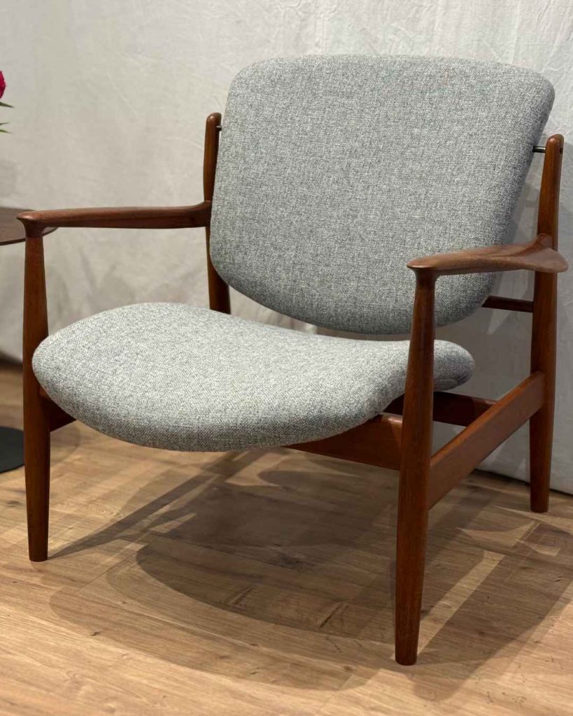 Fertig neu bezogener Finn Juhl 136 Sessel in hellgrauem Wollstoff, Schrägansicht von vorne, Teakholzgestell, Werkstatt Die Raumausstatterin