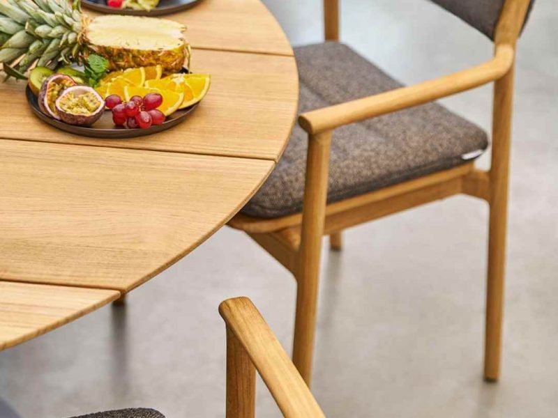 Weishäupl Teva Armlehnstühle aus Teakholz an rundem Tisch mit Früchteplatte, Detailansicht