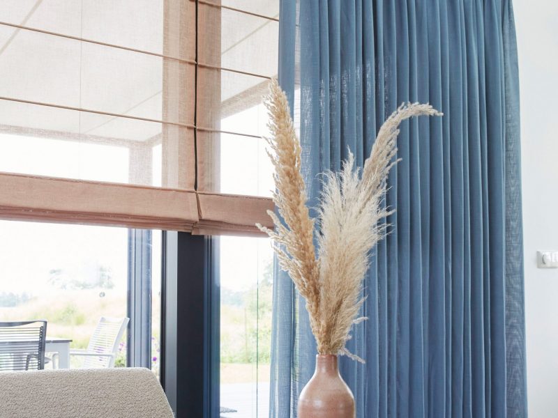 Inspiration von A House of Happiness: Kombination aus transparenten Rollos in Naturtönen und Vorhängen in Blau, modernes Wohnzimmer mit wohnlicher Atmosphäre.