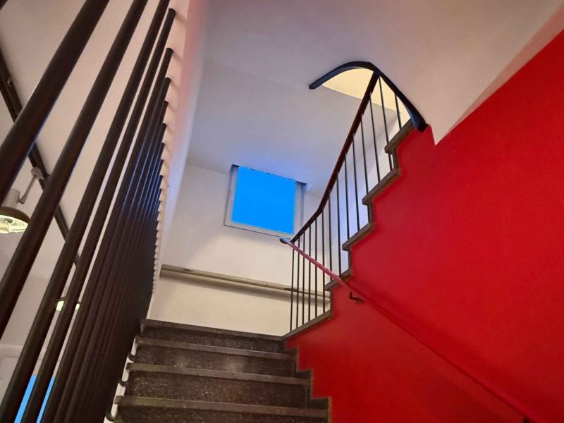 Blick durch das Treppenhaus nach oben mit installierten Deckenpaneelen zur Verbesserung der Raumakustik