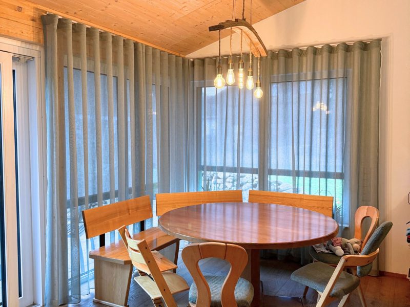 Essbereich mit maßgefertigten Vorhängen aus dem Stoff ‚Maran‘ von A House of Happiness im Farbton Salbei, genäht und montiert von Die Raumausstatterin im Allgäu.